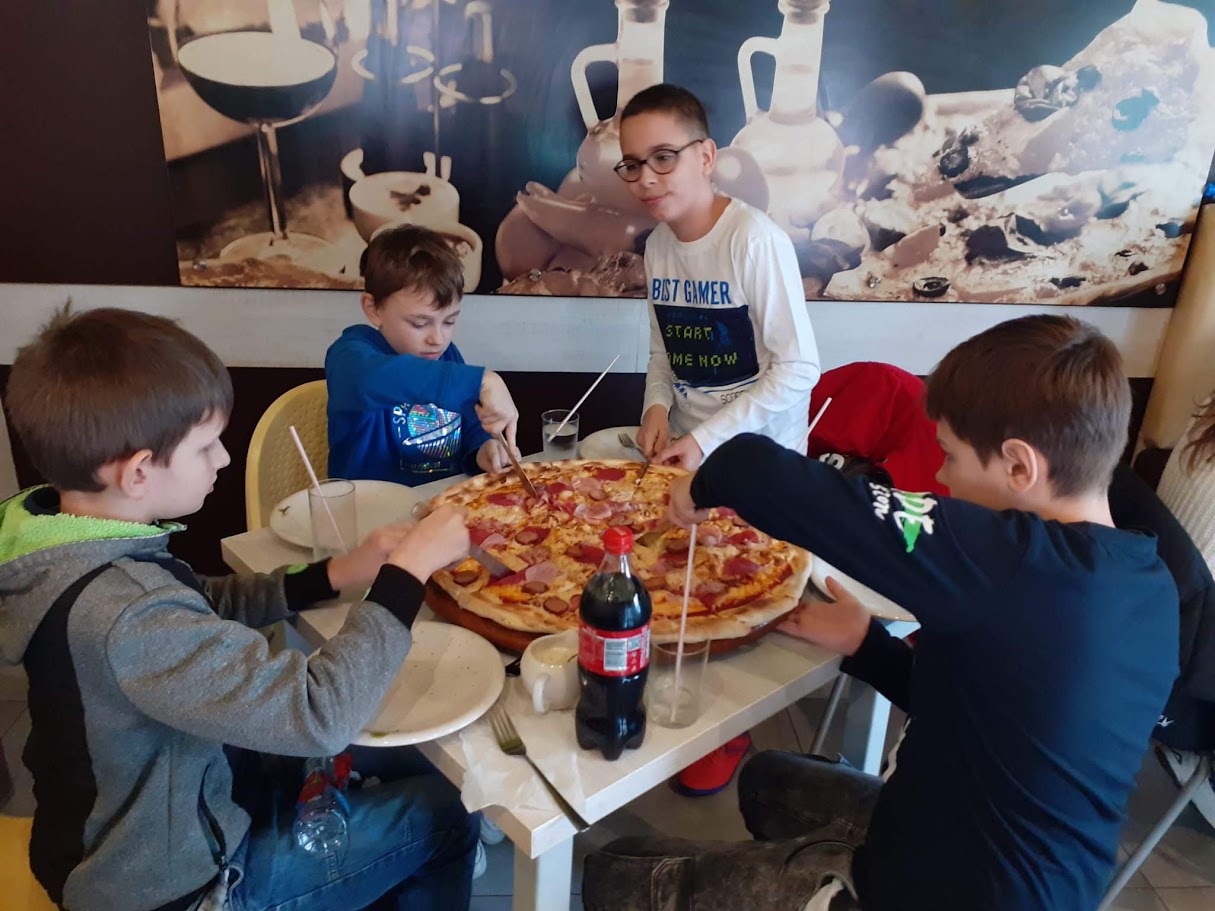 uczniowie jedzą pizzę 